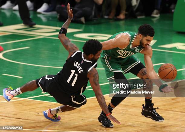 Jayson Tatum of the Boston Celtics and Kyrie Irving of the Brooklyn Nets dive for a loose ball during the fourth quarter of Game Two of the Eastern...