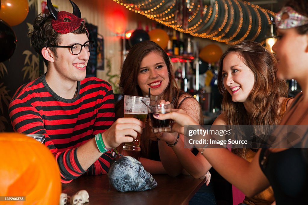 Young friends toasting drinks in bar