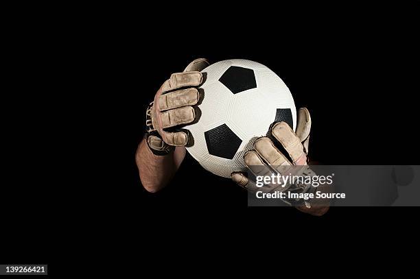 goalkeeper holding football - トレーニンググローブ ストックフォトと画像