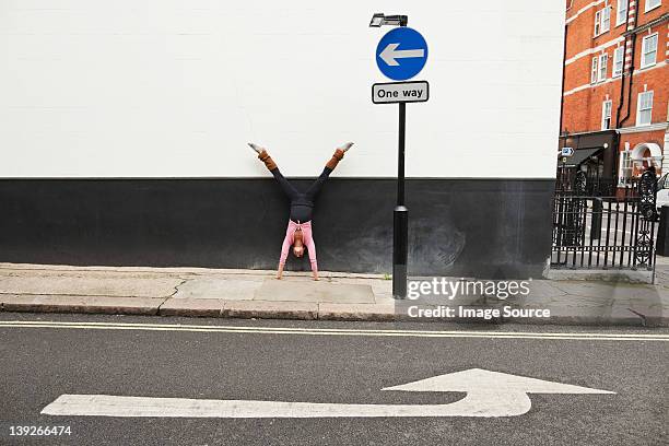 woman performing handstand on pavement - no choice stock pictures, royalty-free photos & images