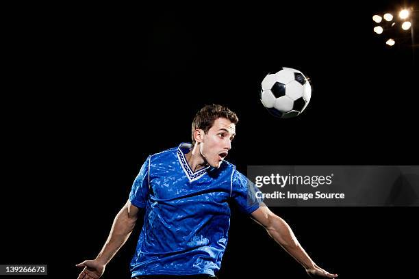 junger mann springen auf kopf soccer ball - kopfball stock-fotos und bilder