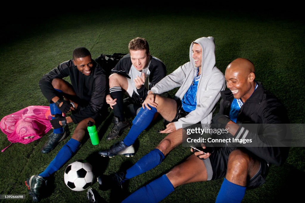 Soccer team resting on pitch after game