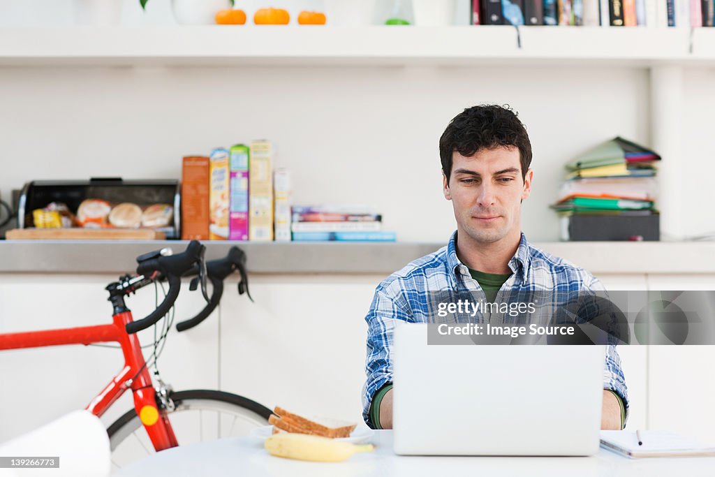 Mid adult man using laptop at home