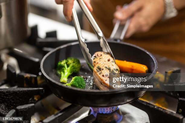 chef prepares duck breast with fresh vegetables in a pan. - chef preparing food stockfoto's en -beelden