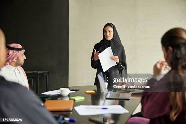 early 20s saudi businesswoman presenting ideas to team - middle east people stock pictures, royalty-free photos & images