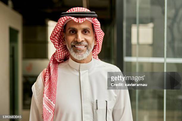 indoor-porträt einer bärtigen saudischen führungskraft im modernen büro - saudi guy stock-fotos und bilder