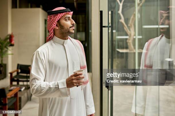 indoor-porträt des geschäftsmannes der späten 20er jahre in riad mit kaffee - saudi arabia people stock-fotos und bilder
