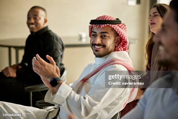 late 20s riyadh businessman showing approval in meeting - suadi arabia stockfoto's en -beelden