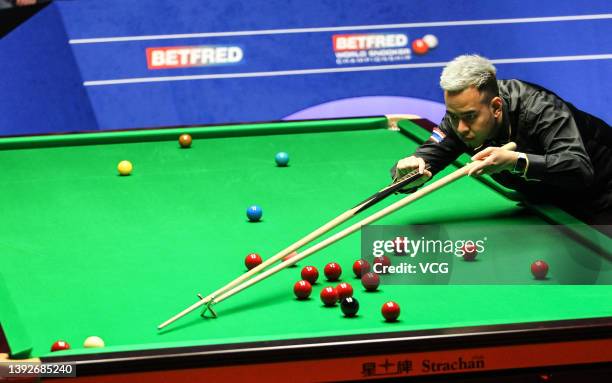 Noppon Saengkham of Thailand plays a shot in the first round match against Luca Brecel of Belgium on day five of the 2022 Betfred World Snooker...