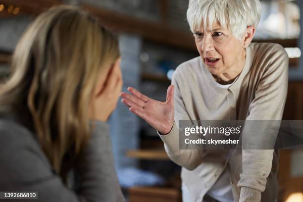 ältere alleinerziehende mutter, die mit ihrer erwachsenen tochter zu hause streitet. - streiten stock-fotos und bilder