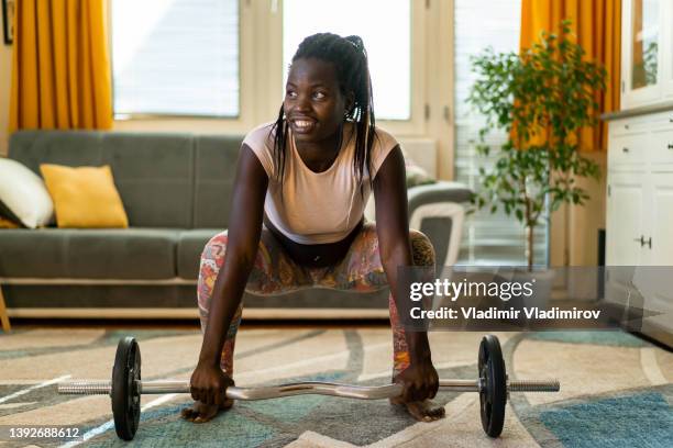 a woman crouching ready to lift the weights - black female bodybuilder stock pictures, royalty-free photos & images