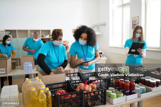 group of mixed race people working in charitable foundation - refugee aid stock pictures, royalty-free photos & images