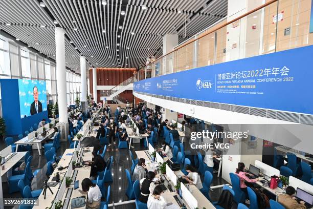 Media staff at the Boao Forum for Asia Press Center watch a screen showing a live broadcast of UN secretary-general Ban Ki-moon speaking during the...