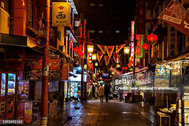 night at nankinmachi chinatown with illuminated neon street signs and lunar new year decorations, kobe, japan - 2018 chinese new year stock-fotos und bilder