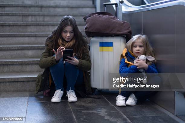 ukrainian woman with daughter at train station leaving ukraine due to russian invasion in ukraine. - displaced stock pictures, royalty-free photos & images