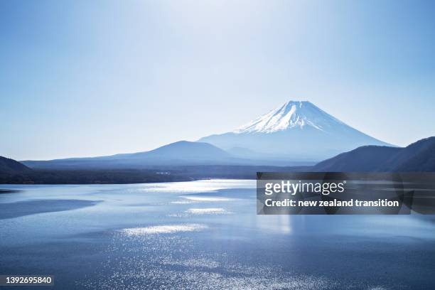snow capped mt fuji with sparkling water ripples in lake motosu monochrome, japan - fuji stockfoto's en -beelden