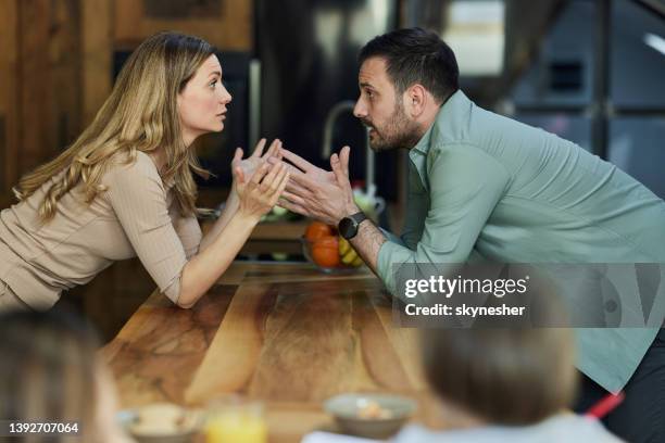 una pareja joven teniendo una discusión en casa. - lucho en familia fotografías e imágenes de stock