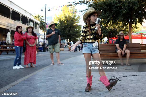 Young girl from the band 'UV' busks off Peel St on April 21, 2022 in Tamworth, Australia. The Tamworth Country Music Festival is celebrating 50 years...