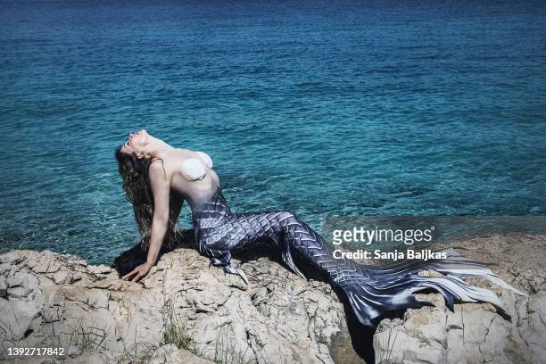woman mermaid on rock - mermaid tail stock pictures, royalty-free photos & images