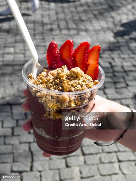 acai smoothie with strawberries in the city street. - acai stock-fotos und bilder