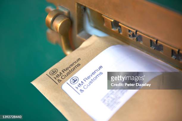 Photograph shows a front door letter box with HMRC envelope, Her Majestys Revenue and Customs reminding of the date that self-assessment tax returns...