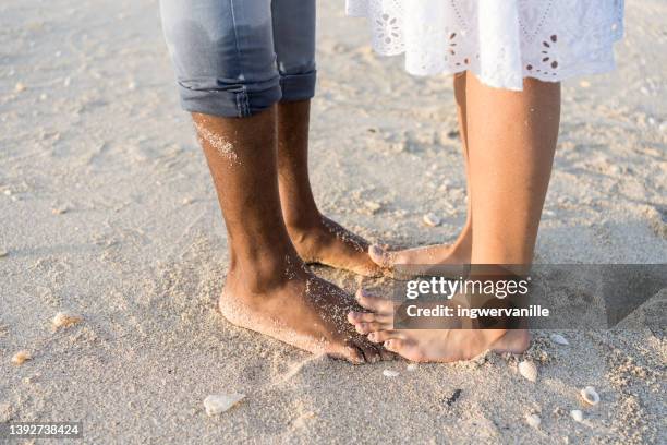 black and white feet in beach sand - black feet couple stock pictures, royalty-free photos & images