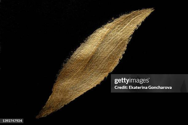 a beautiful smear of gold paint in the form of a plaque on a black isolated background. - gold plaque stock-fotos und bilder