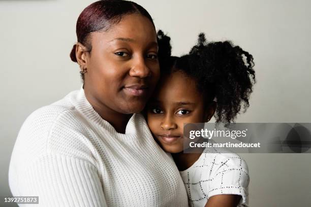 portrait of mother and daughter in living room. - alleenstaande moeder stockfoto's en -beelden