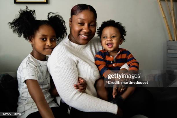 portrait of mother and children in living room. - family with two children stock pictures, royalty-free photos & images