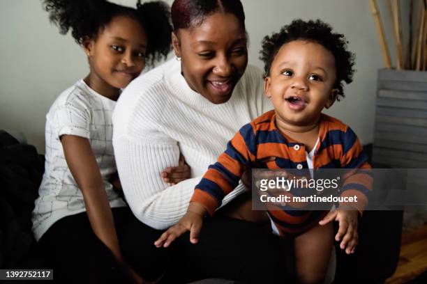 portrait of mother and children in living room. - afro caribbean ethnicity stock pictures, royalty-free photos & images