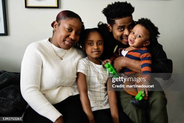 retrato de la familia de cuatro en la sala de estar. - haitian ethnicity fotografías e imágenes de stock