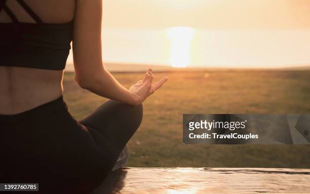 close up hands. woman do yoga relax outdoor. woman exercising pose vital and meditation for fitness lifestyle club at the outdoors nature background. healthy and yoga concept - sunrise yoga foto e immagini stock