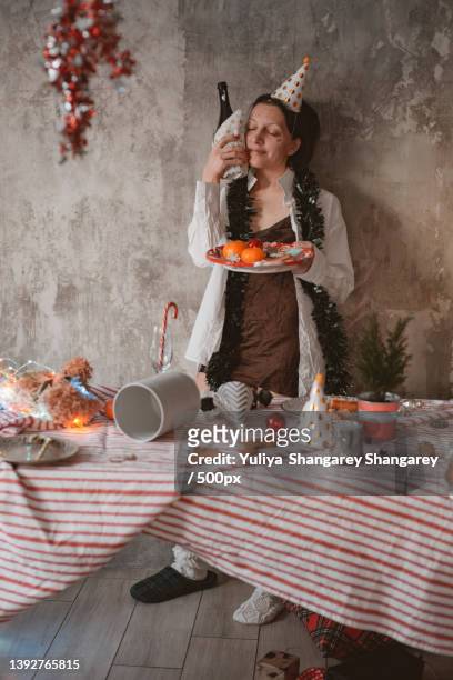 woman has a hangover after a holiday in the morning with a bottle of wine - hangover after party stockfoto's en -beelden