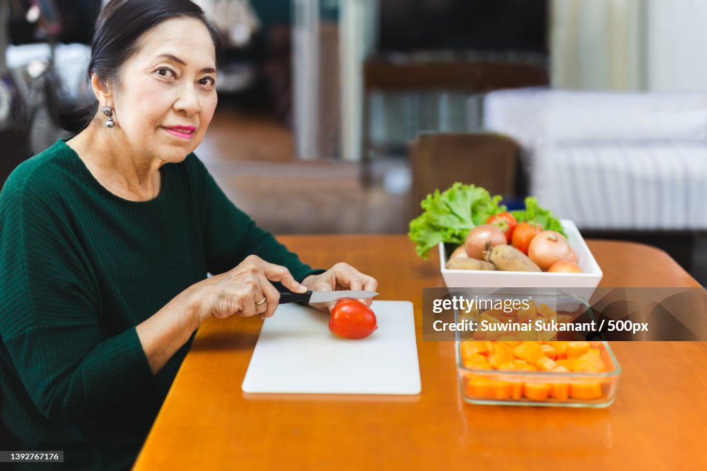 Healthy eating,Senior woman chopping tomato for cooking,Thailand