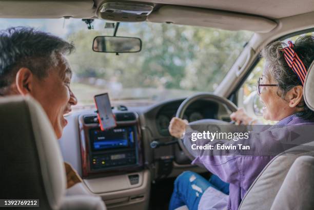 road trip rear view asian chinese senior couple travelling with motor home at rural area with mobile app map direction guidance - chinese car home stockfoto's en -beelden