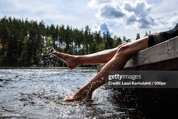 summer and water,low section of woman splashing water in lake against sky,helsinki,finland - finnland stock-fotos und bilder