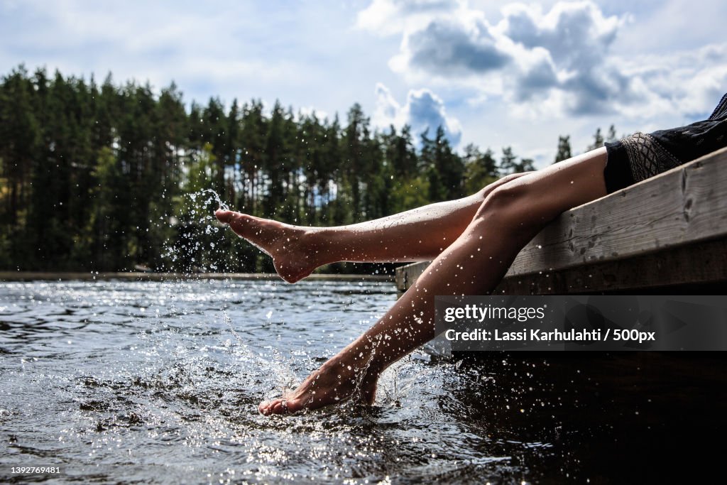 Summer and Water,Low section of woman splashing water in lake against sky,Helsinki,Finland