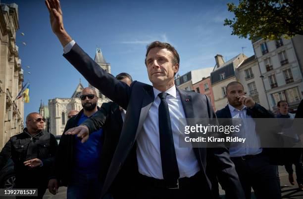 French President Emmanuel Macron waves to supporters and local residents of Saint-Denis as part of his campaign trail as he bids for a second term as...
