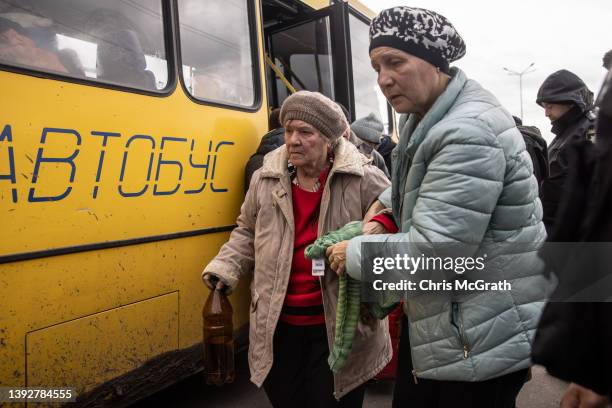 Women from Mariupol disembark a bus after a convoy of vehicles arrived at an evacuation point, carrying people from Mariupol, Melitopol and...