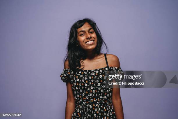 portrait of a young adult woman against a purple background - sri lankan ethnicity stock pictures, royalty-free photos & images