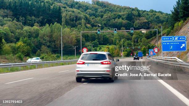 car point of view, control traffic lights at motorway access to a tunnel area. - coche carretera fotografías e imágenes de stock