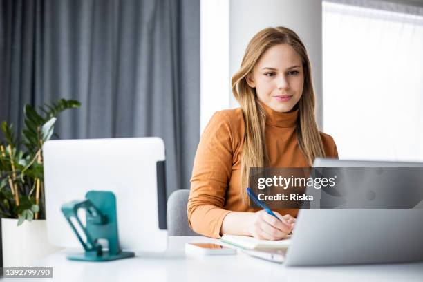 young woman concentrating while working - blond haar stockfoto's en -beelden