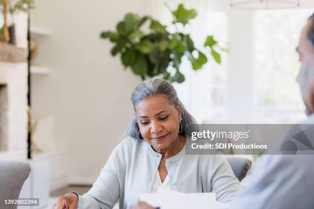 looking at paperwork, senior widow listens to male accountant - reading contract stock pictures, royalty-free photos & images