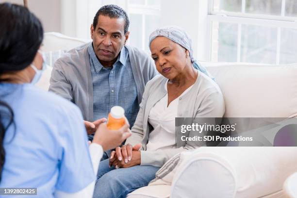 unrecognizable nurse explains chemo side effects to serious senior couple - chemotherapy stock pictures, royalty-free photos & images