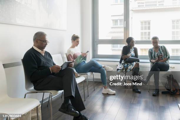 patients at doctors surgery waiting room - waiting room stockfoto's en -beelden