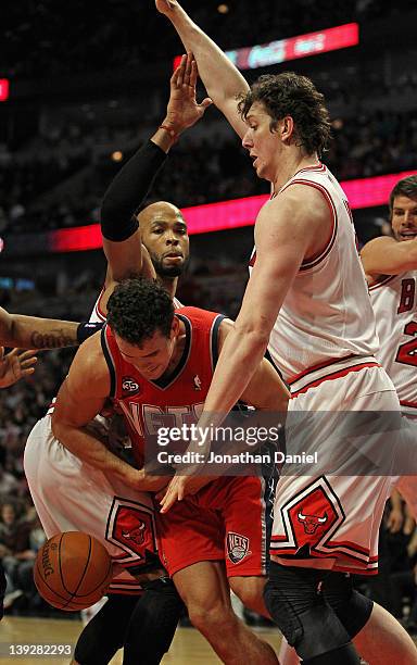 Kris Humphries of the New Jersey Nets looses control of the ball after being trapped by Taj Gibson, Omer Asik and Kyle Korver of the Chicago Bulls at...