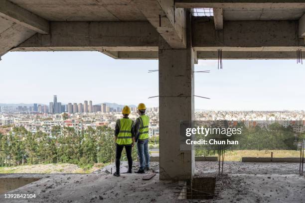 male and female engineers stand in unfinished buildings to discuss future urban development - asian architect 40 imagens e fotografias de stock