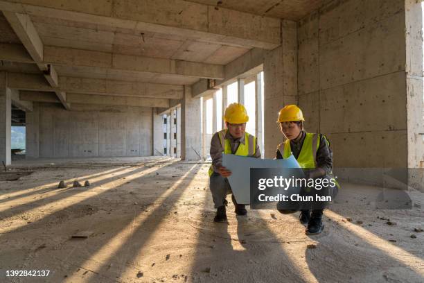 データを比較する図面を持つ男性と女性の建設エンジニア - laborer ストックフォトと画像