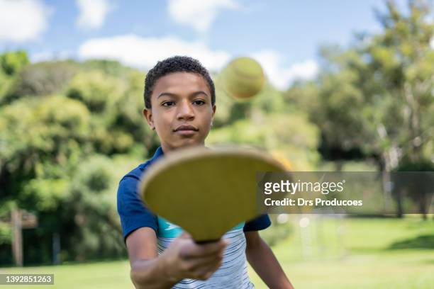 boy playing with paddleball - tennis boy stock pictures, royalty-free photos & images