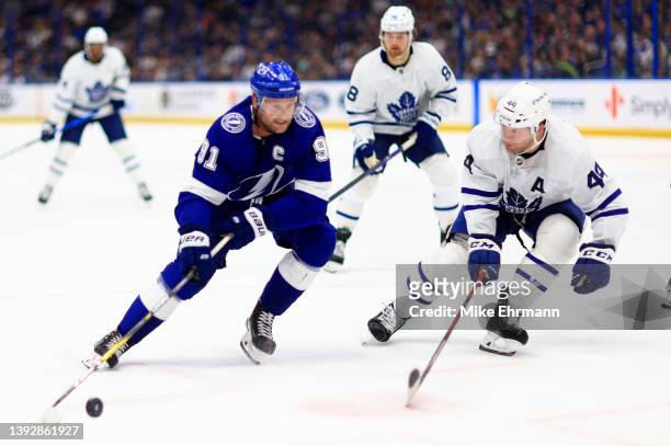Steven Stamkos of the Tampa Bay Lightning and Morgan Rielly of the Toronto Maple Leafs fight for the puck in the second period during a game at...